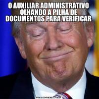 O AUXILIAR ADMINISTRATIVO OLHANDO A PILHA DE DOCUMENTOS PARA VERIFICAR